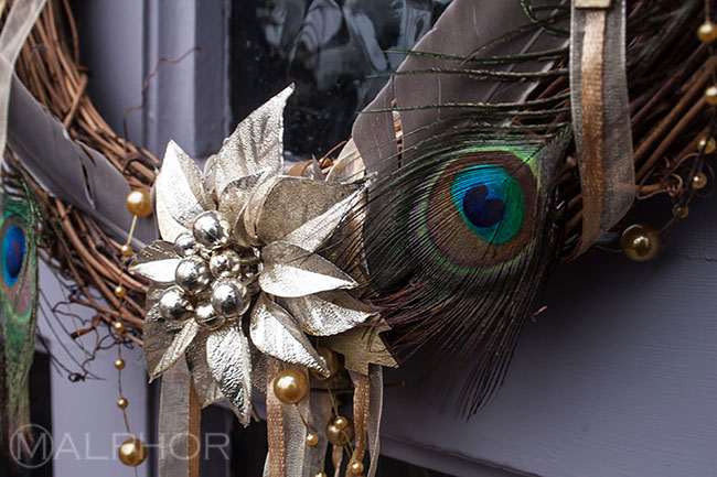 Peacock feathers Christmas wreath on purple door